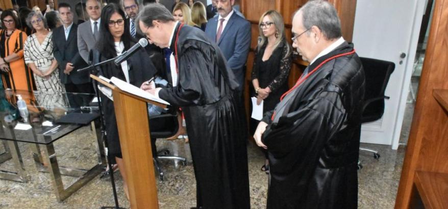 O agora desembargador federal Paulo Pereira Leite Filho veste uma túnica preta e assina o ato de posse, observado à direita por Messod Azulay, também vestindo túnica. Ao fundo vê-se várias pessoas acompanhando a cerimônia.