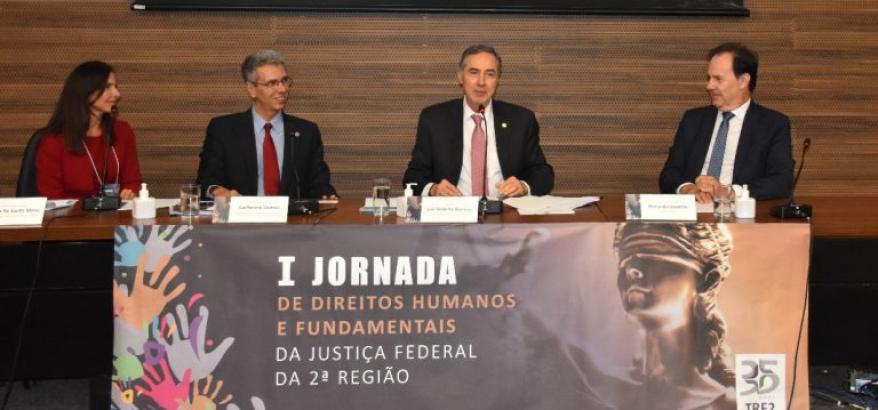 Imagem da mesa do evento. Abaixo, o seguinte título: "O presidente do STF e do CNJ, ministro Luís Roberto Barroso, ministrou palestra de encerramento da “I Jornada de Direitos Humanos e Fundamentais da Justiça Federal da Segunda Região”
